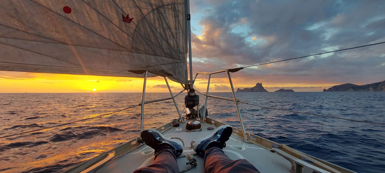 Navegando de vuelta a Valencia con el peñon Es Vedrá, en Ibiza,  por la proa